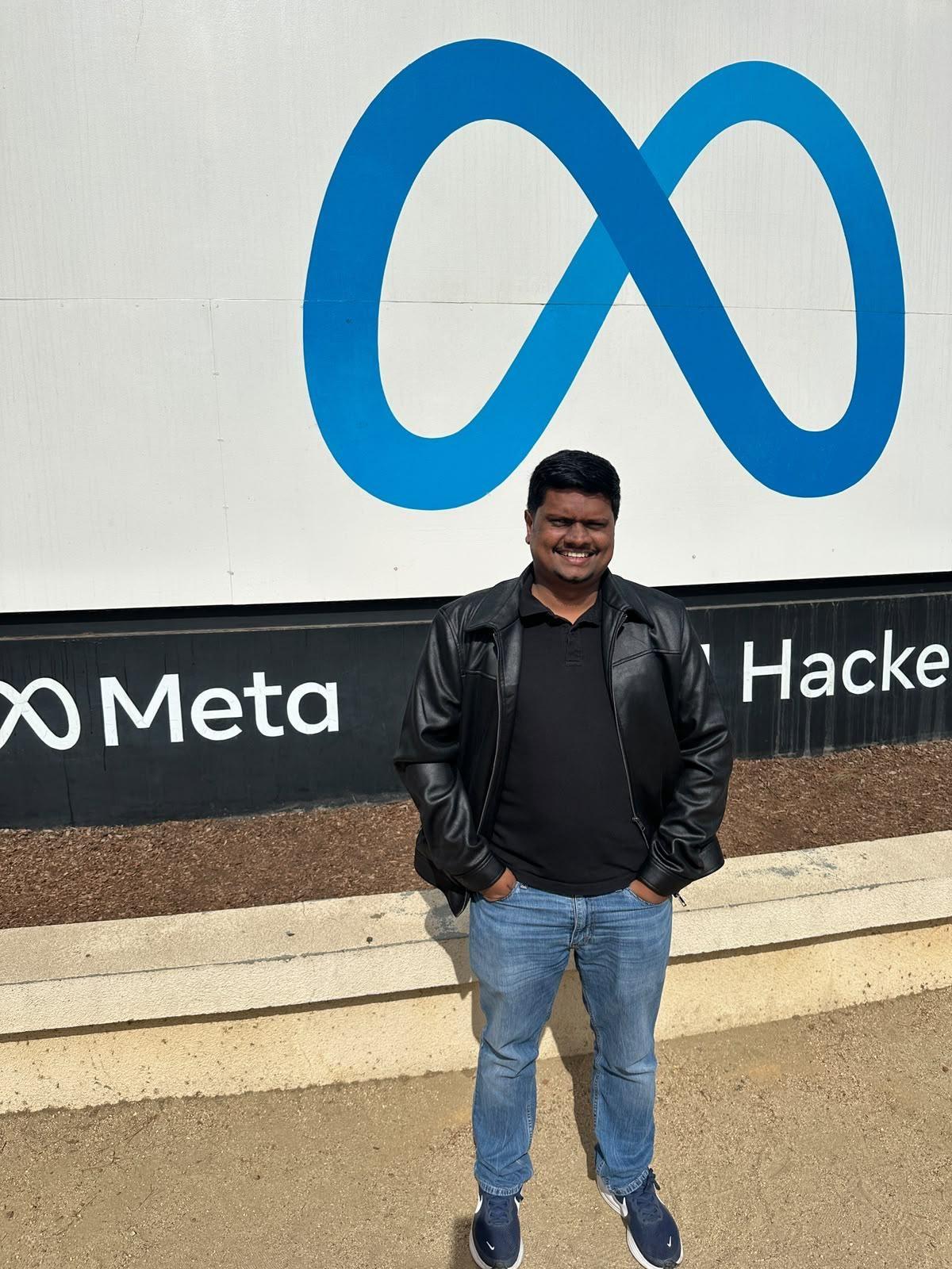 In front of the Meta sign at 1 Hacker Way, Menlo Park